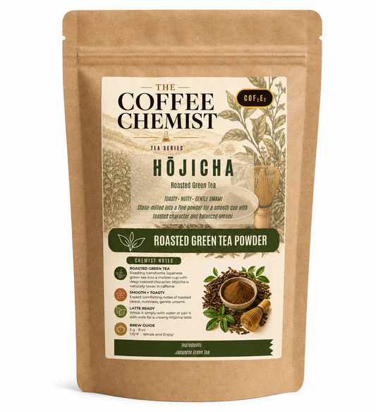 A stand-up kraft paper pouch of The Coffee Chemist Hōjicha Roasted Green Tea Powder, featuring a cream and green label with illustrations of tea plants and loose tea leaves.