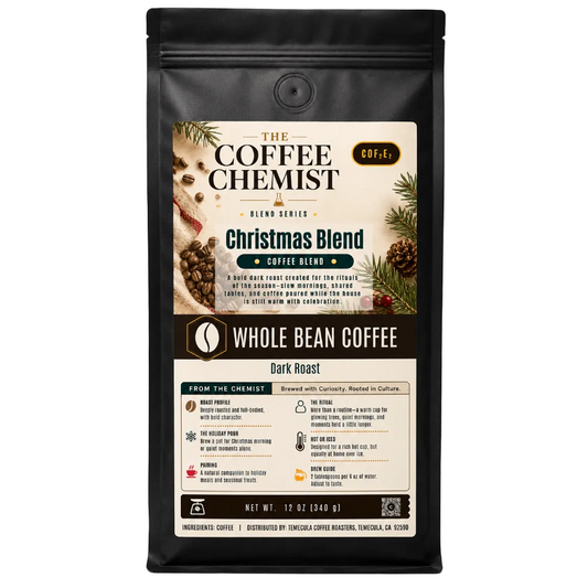 A 12 oz bag of The Coffee Chemist Christmas Blend whole bean coffee, dark roast, in a black resealable stand-up pouch with a detailed holiday-themed label.